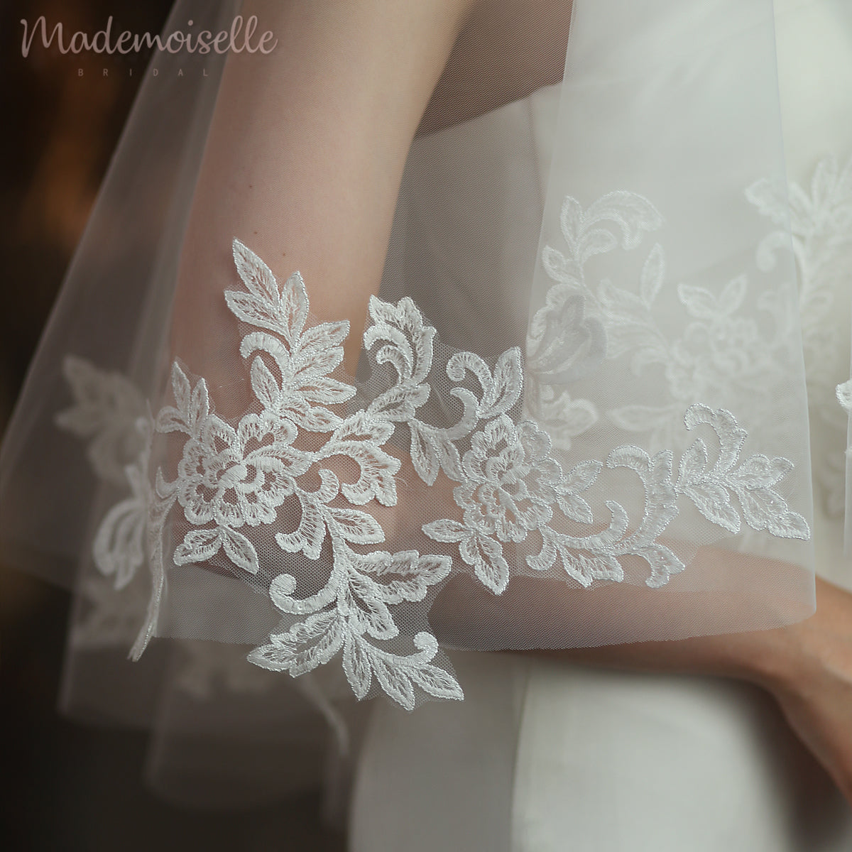 An elegant close-up showcasing the intricate lace details of a bride's wedding dress paired with a beautiful veil.
