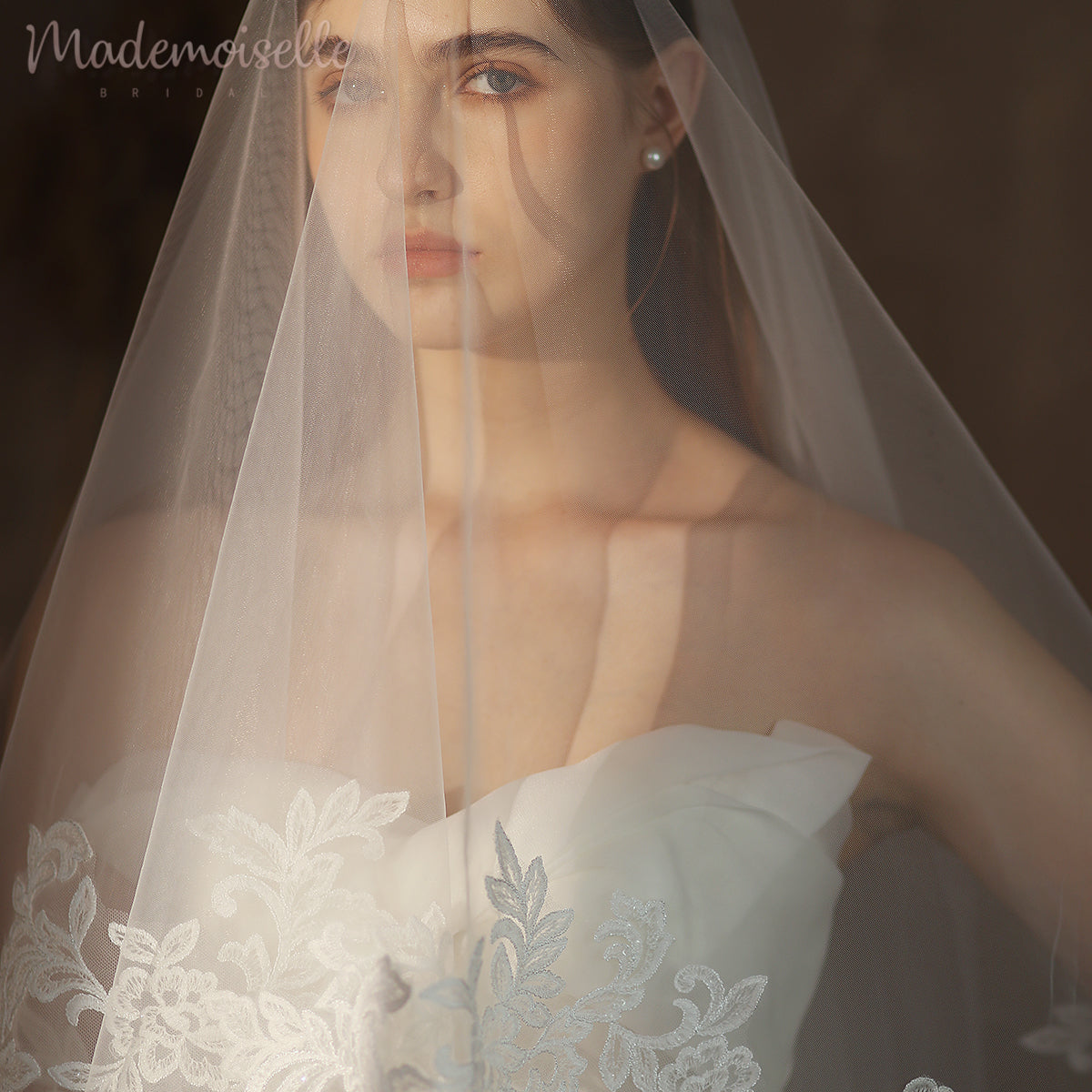 A graceful woman adorned in a delicate wedding veil, embellished with exquisite flowers, radiates elegance and romance.