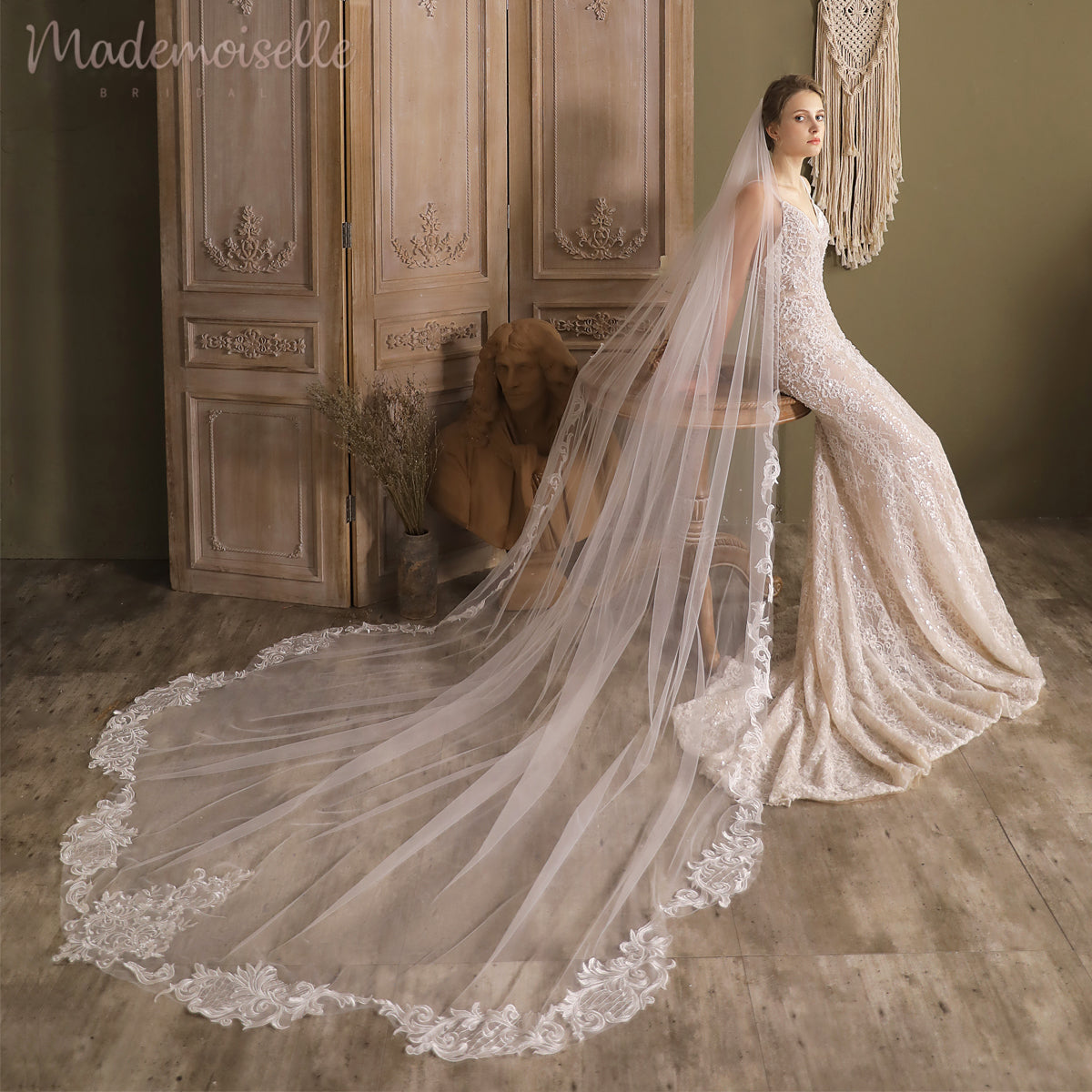 Elegantly posed, a woman in a wedding dress adorned with lace appliqué edges captures a moment of pure romance.