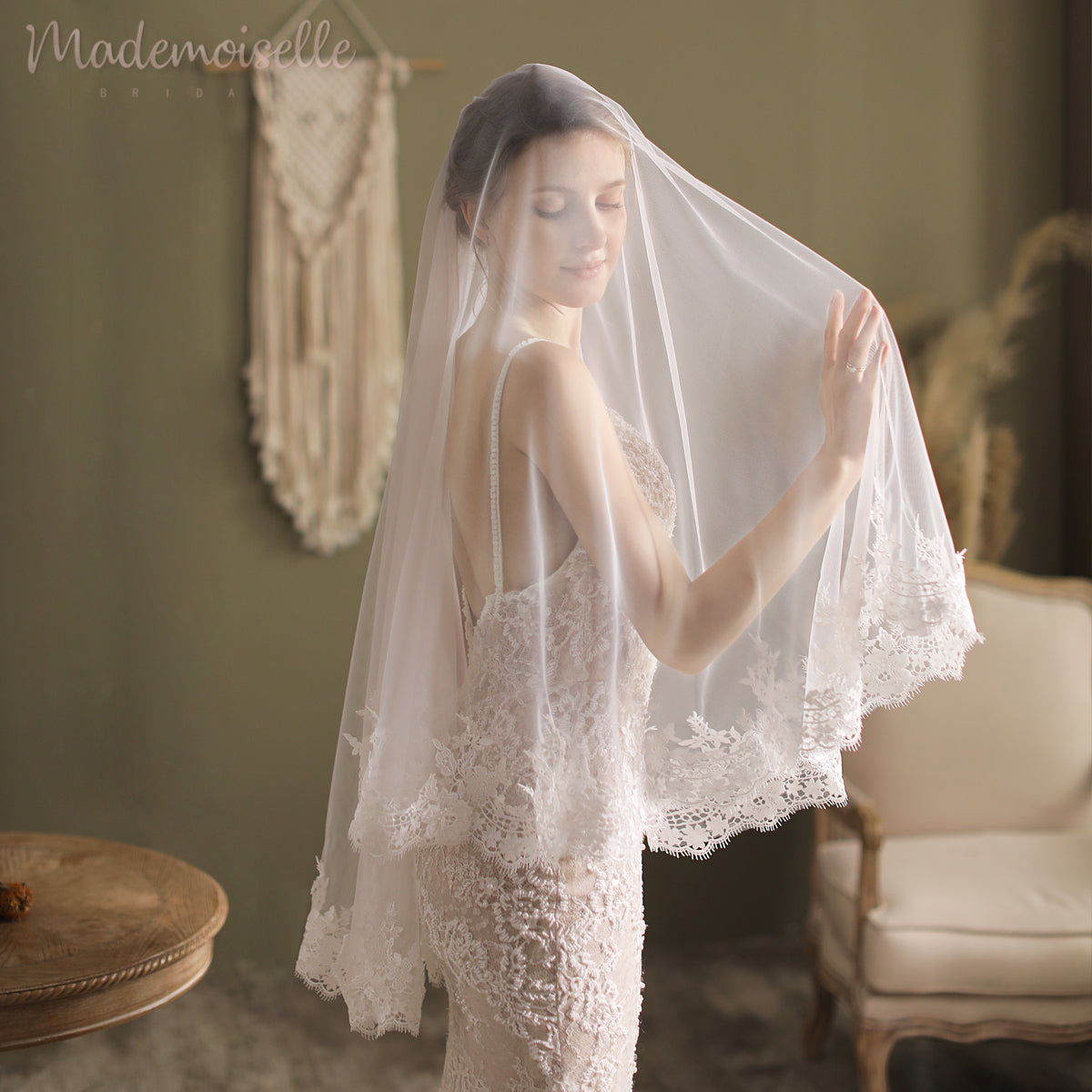 A breathtaking bride in a white lace veil, elegantly framed by a luxurious lace appliqué edge, epitomizing bridal sophistication.
