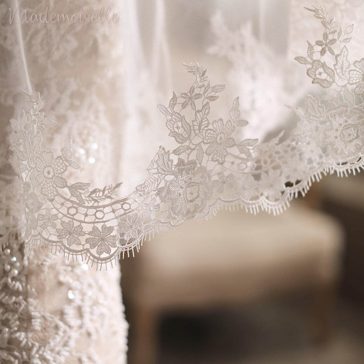 A stunning close-up of a wedding dress adorned with intricate lace appliqué edges, epitomizing timeless bridal beauty.