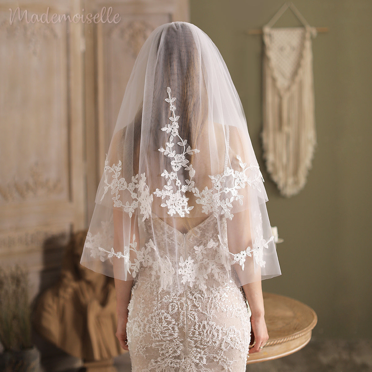 The back view of a bride in a stunning wedding veil, featuring intricate lace appliqué edges, radiating grace and sophistication.