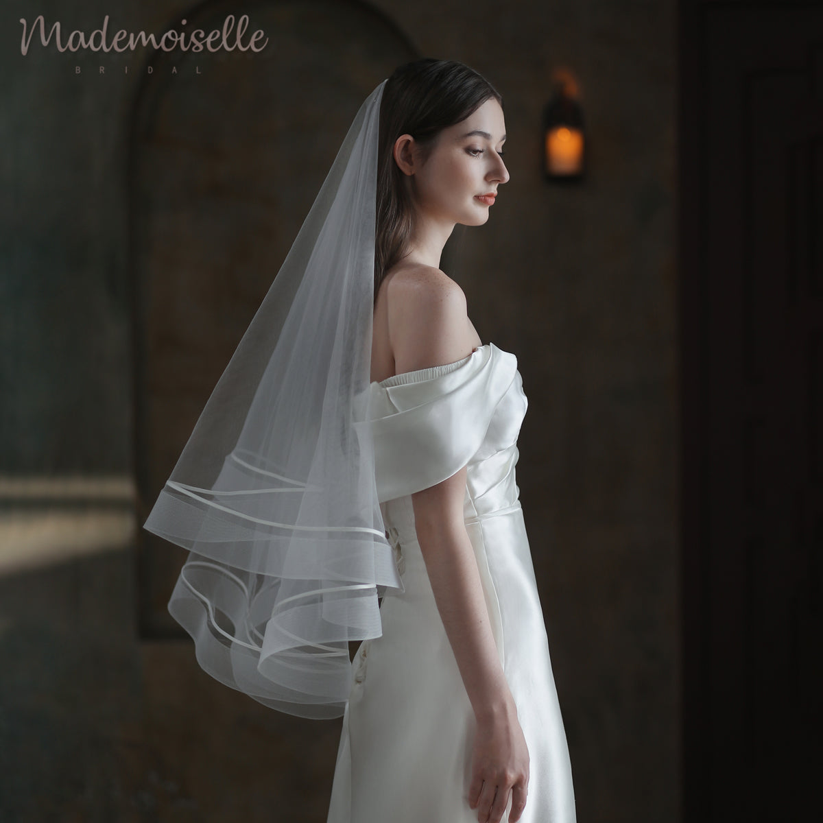 A beautiful bride showcases her white wedding dress, elegantly paired with a soft, flowing veil featuring horsehair trim