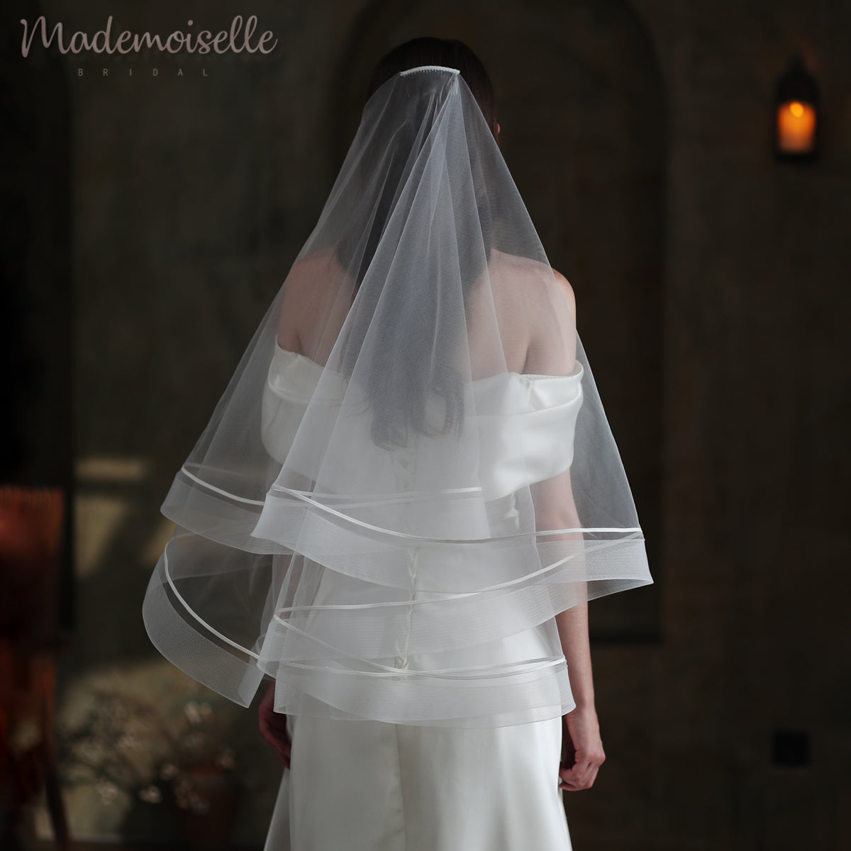 The back view of a bride in a stunning wedding veil, embellished with luxurious horsehair trim, exuding grace and elegance.