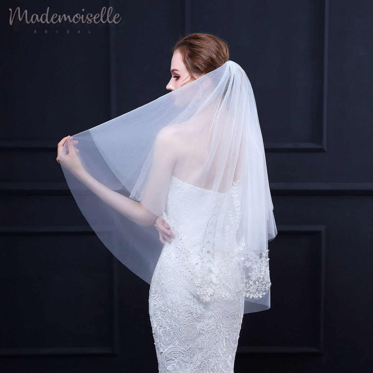 A bride in a white wedding dress and veil, radiating elegance and joy on her special day.