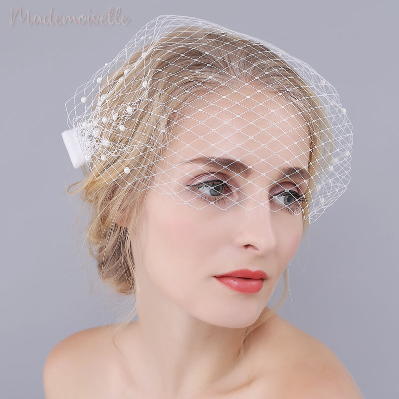 Model wearing white netted birdcage wedding veil with pearl beads