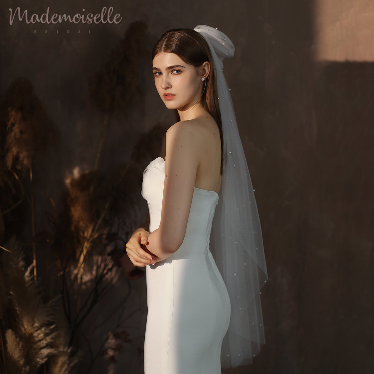 Dressed in a luxurious white wedding gown and a graceful veil, the bride captures the essence of love and sophistication.