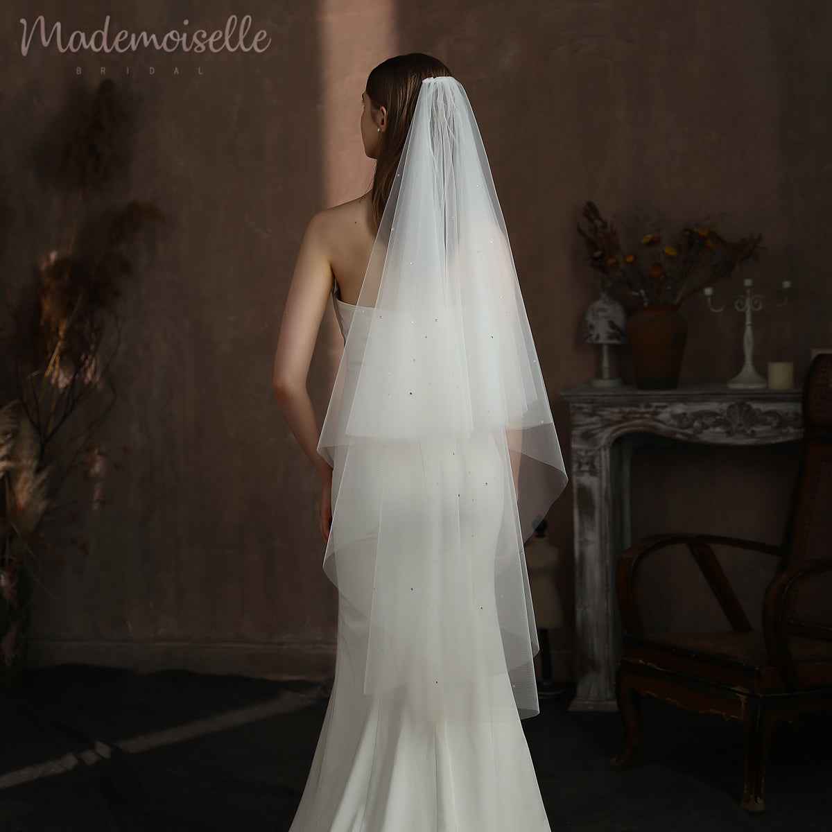 A bride&#39;s elegant back adorned in a stunning wedding dress, complemented by a delicate veil, radiating timeless beauty.