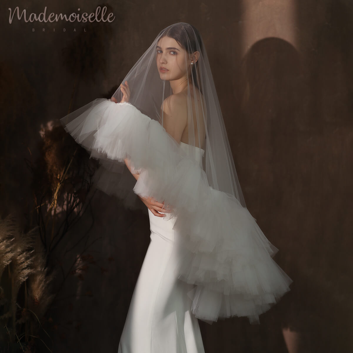 A stunning bride in a delicate ruffle-edged wedding veil, capturing the essence of love and celebration.