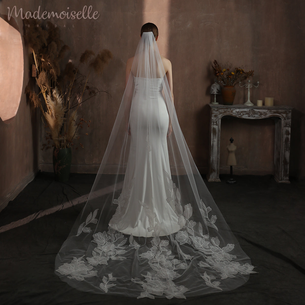 A stunning bride&#39;s back, draped in a long veil with delicate floral lace, capturing the essence of romance and elegance.
