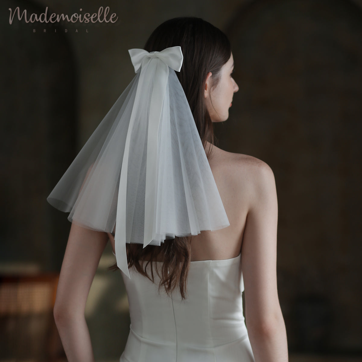 A bride&#39;s elegant back adorned with a delicate veil and a charming bow, exuding grace and timeless beauty.