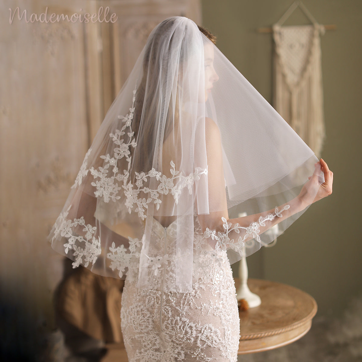 A breathtaking bride in a white lace veil, elegantly framed by a luxurious lace appliqué edge, epitomizing bridal sophistication.