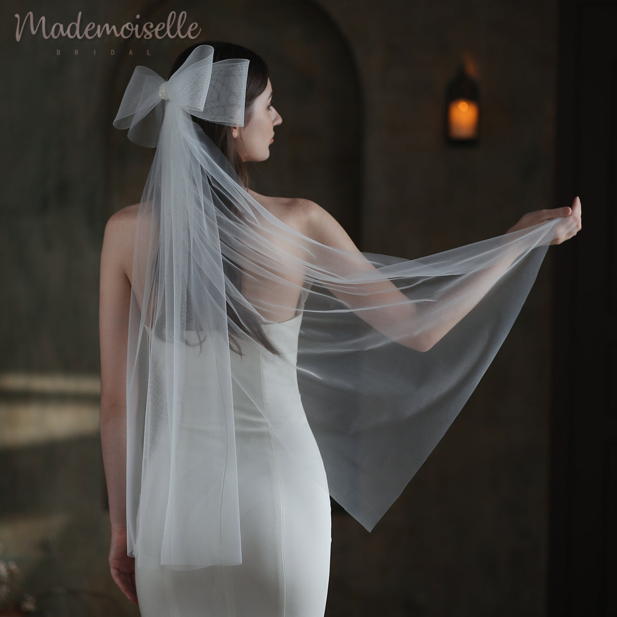 The bride&#39;s exquisite veil, beautifully accented with a charming bow, enhances her enchanting bridal look with elegance.