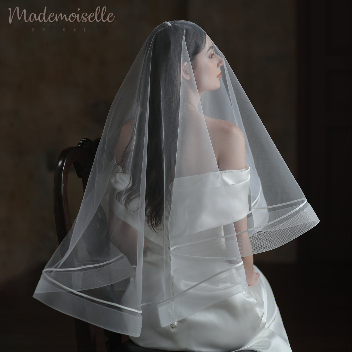 The bride&#39;s stunning veil cascades with a long train, beautifully enhanced by intricate horsehair trim.