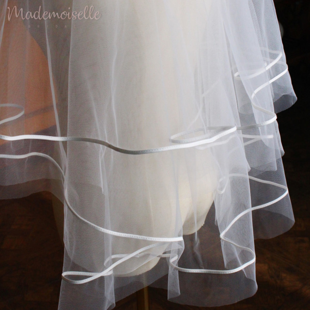 A close-up of an elegant white wedding veil adorned with delicate ribbon trim, exuding timeless beauty and grace.