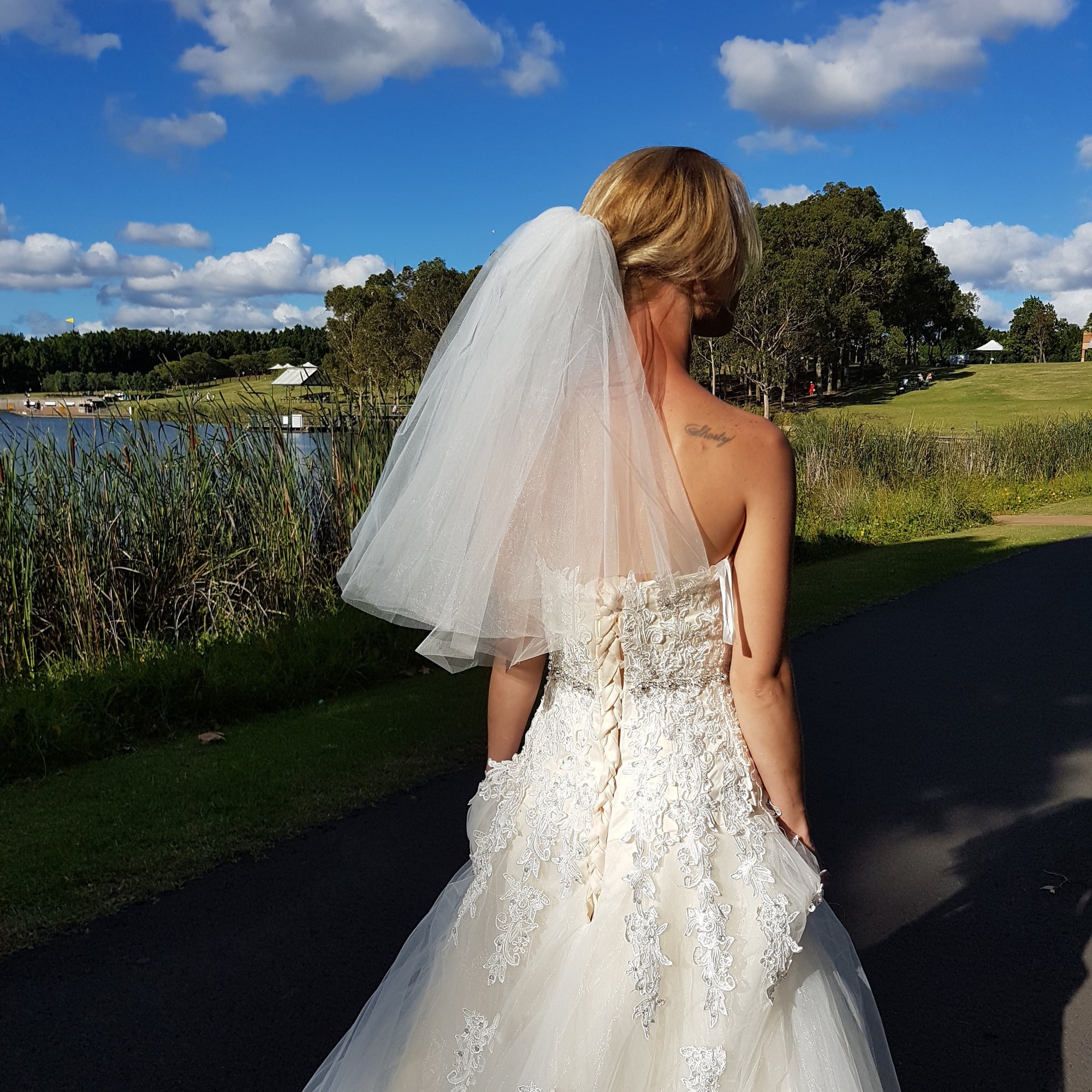 A bride in a beautiful wedding dress poses gracefully for a photo, capturing a moment of joy and elegance.