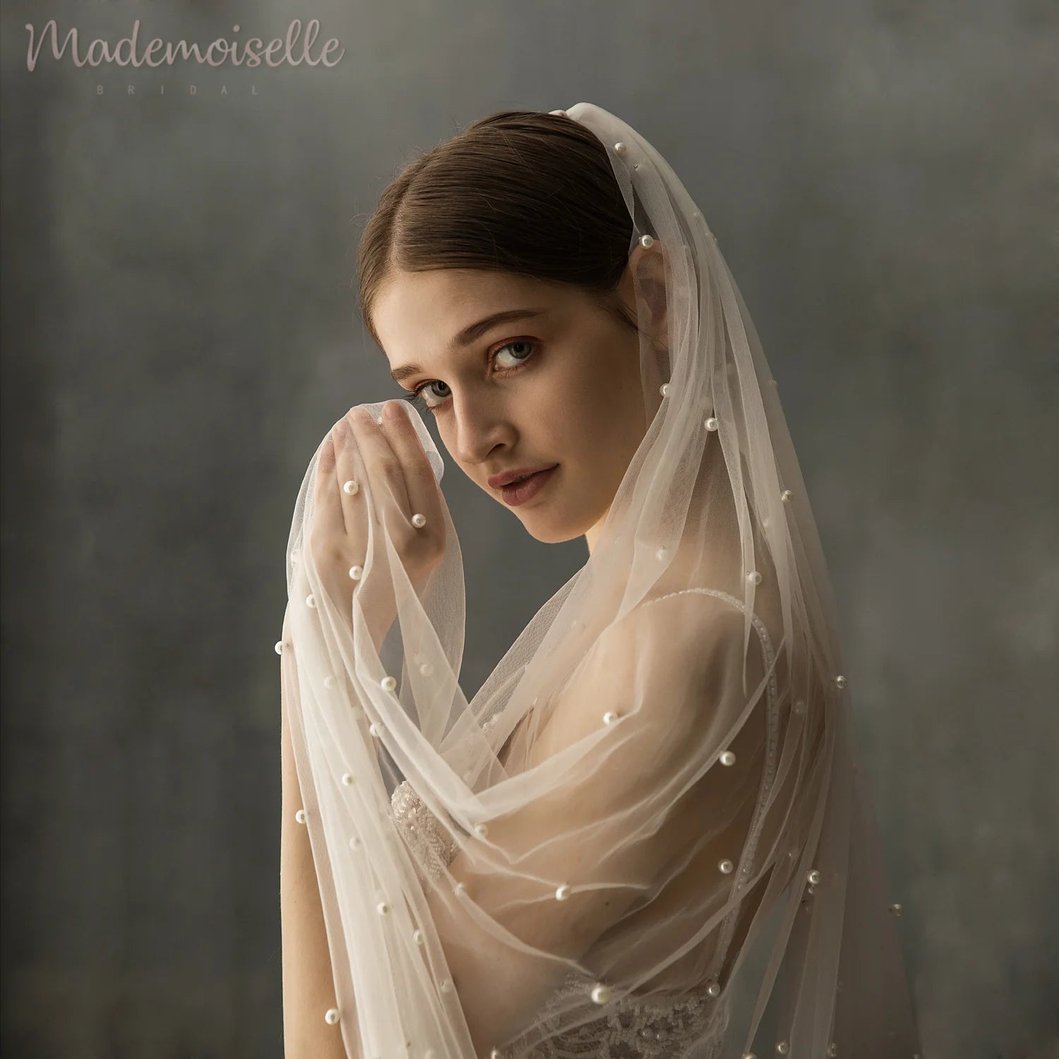 A bride's back view showcasing a long, flowing veil cascading down her gown, creating an elegant silhouette.