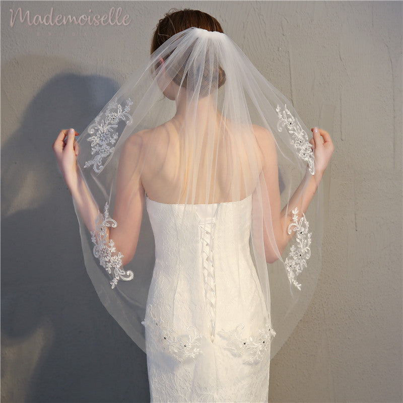 A woman’s back, elegantly draped in a wedding veil, representing the grace and joy of a bride on her momentous occasion.
