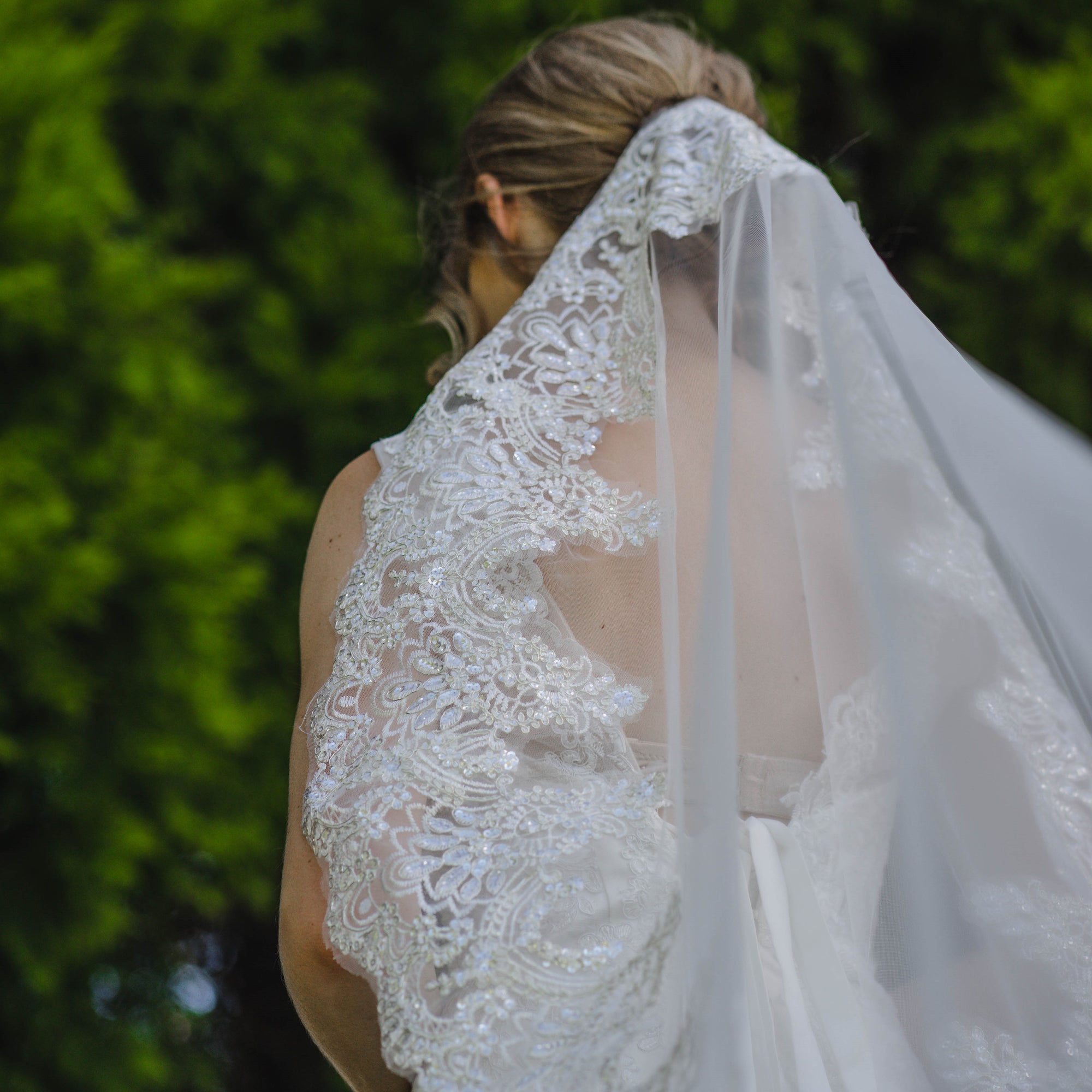 A beautiful bride in a stunning wedding dress stands gracefully by a serene lake, reflecting her joy on this special day.