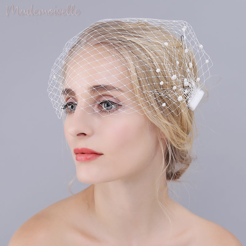 Model wearing white netted birdcage wedding veil with pearl beads