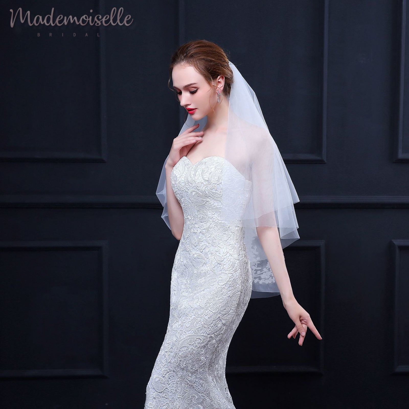 A bride in a white wedding dress and veil, radiating elegance and joy on her special day.